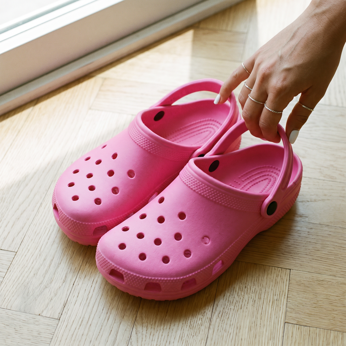 Par do Clog Adulto Gummie rosa no piso de madeira