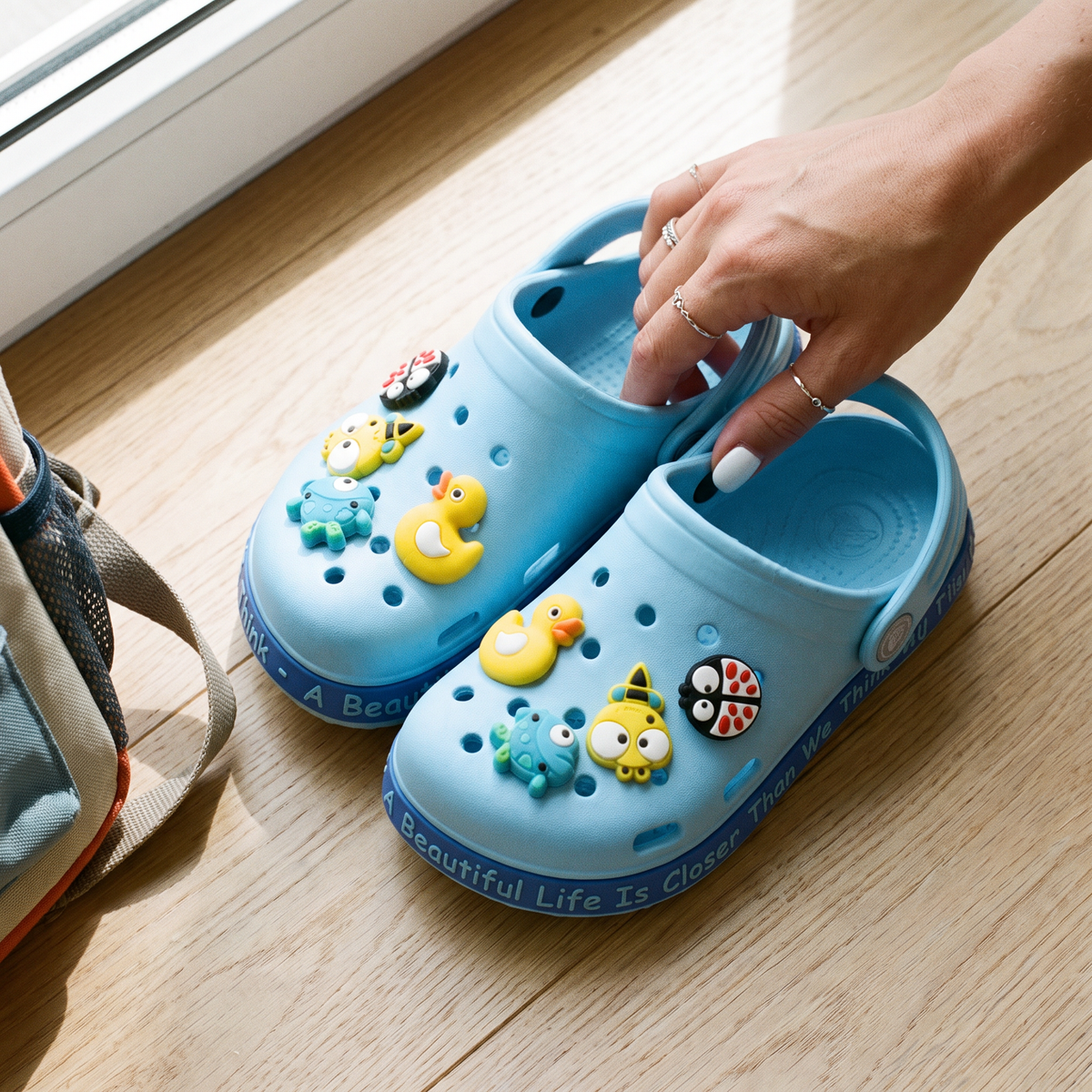 Par do Clog Infantil Zoo azul no piso de madeira